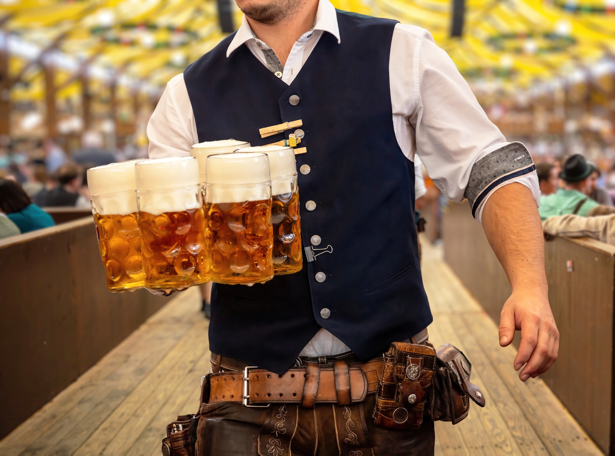 Oktoberfest, Munich. Waiter in traditional Bavarian costume serving beers. Image: Shutterstock