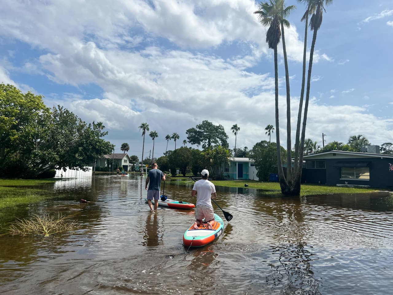 Dustin Pentz, kneeling, paddled to see his home for the first time in Shore Acres, a neighborhood that often floods in St. Petersburg, Fla. Photo: Deborah Acosta/WSJ